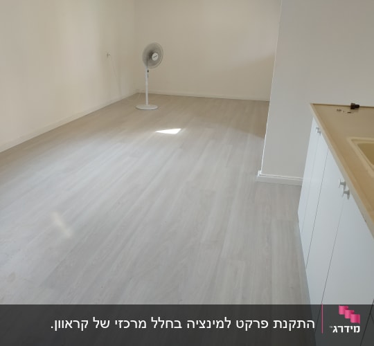 רצפת פרקט בהירה בחדר ריק עם מאוורר